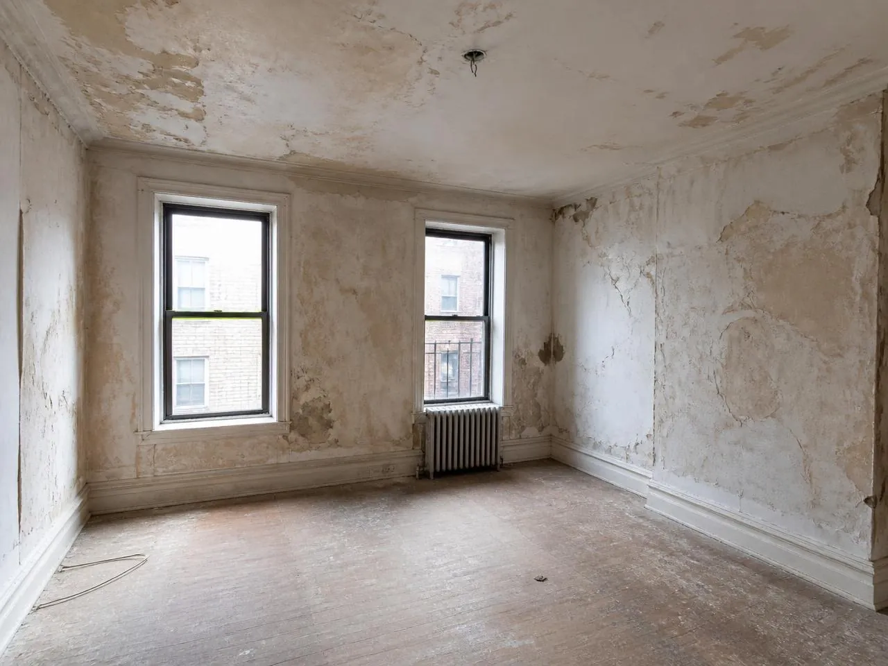 Before painting services NYC — pre-war apartment with cracked, peeling plaster walls and water damage