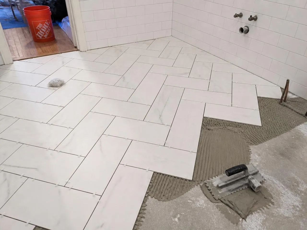 Tile installation NYC — large-format porcelain set in a herringbone pattern with consistent grout joints