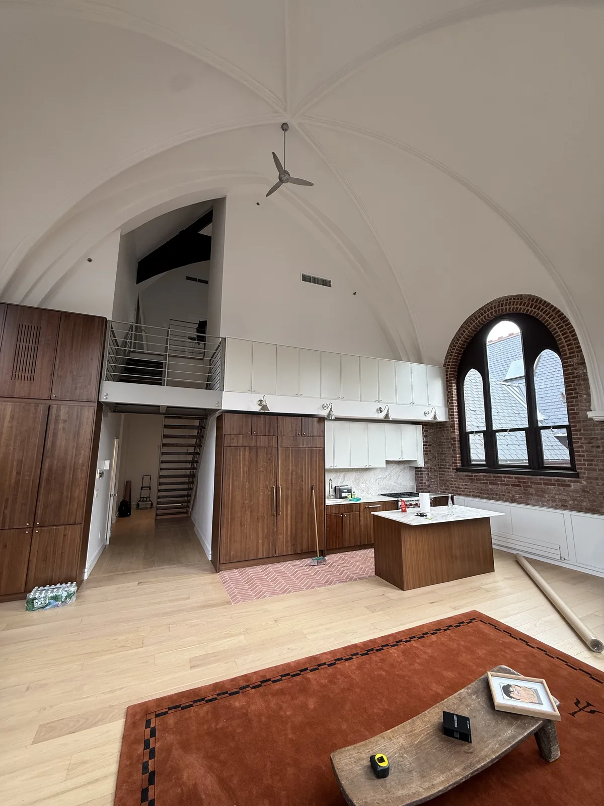 Loft kitchen remodel with vaulted ceiling, walnut cabinetry and exposed brick in New York City