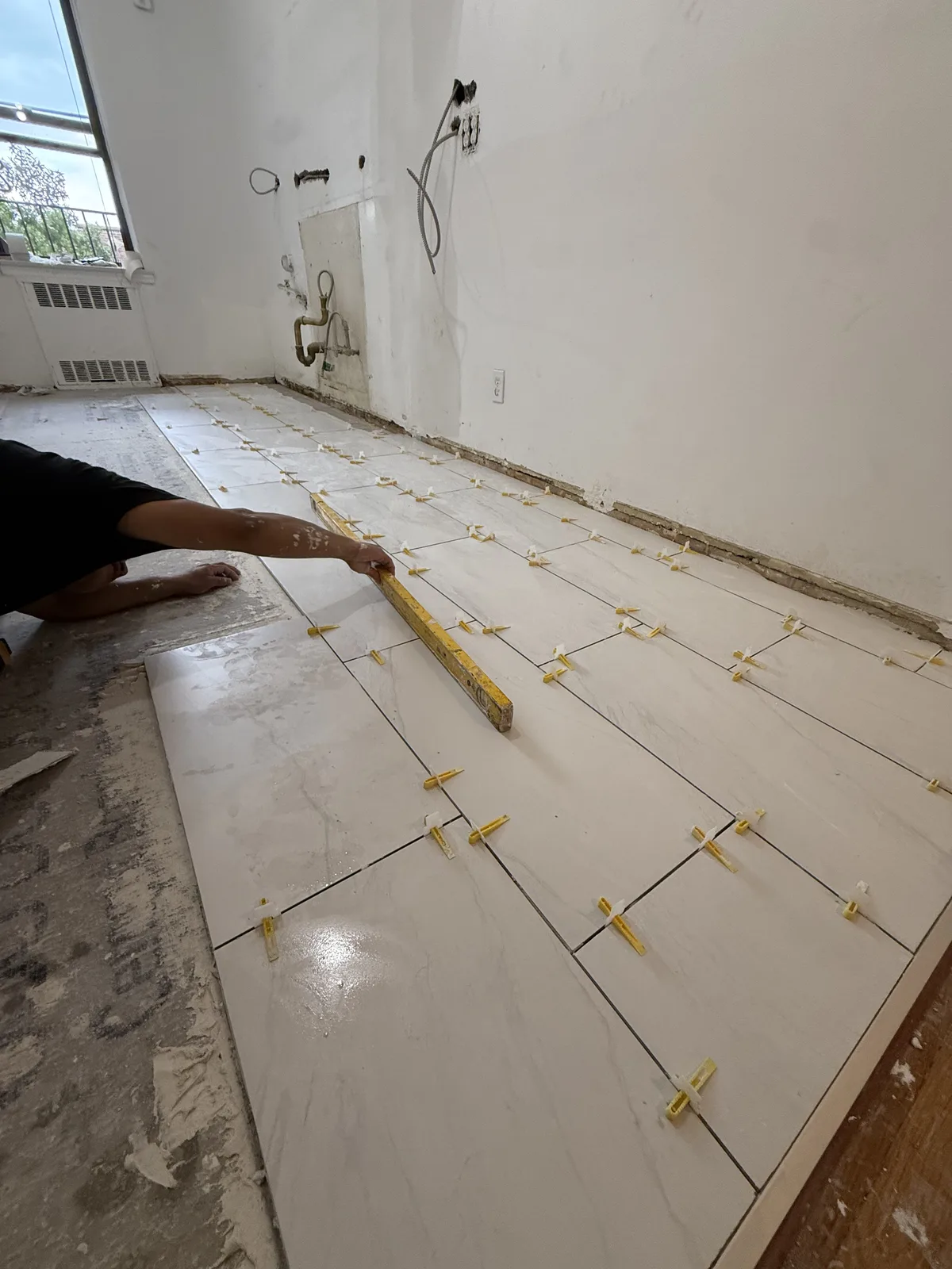 Large-format floor tile installation during an apartment renovation in New York City
