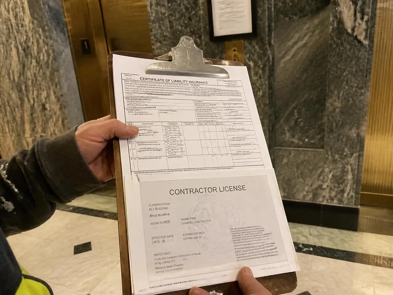 Certificate of liability insurance and NYC contractor license presented in a co-op building lobby