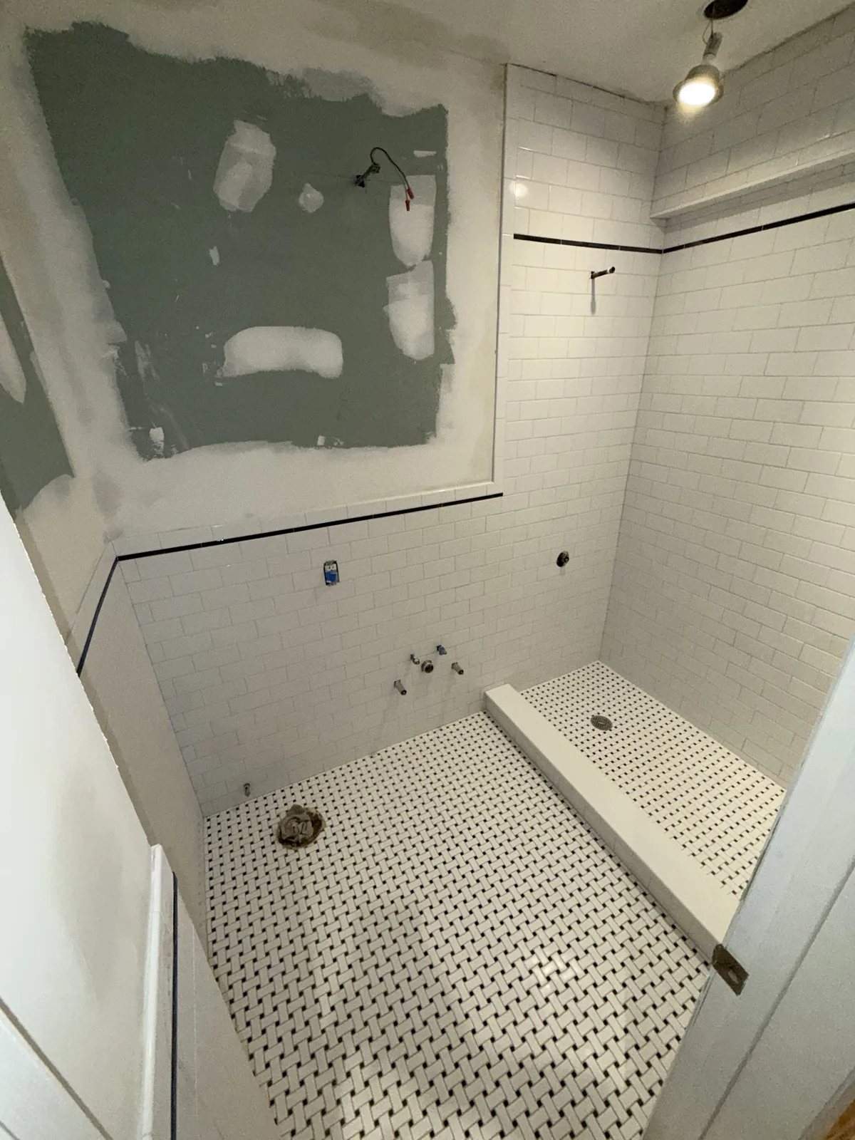 Bathroom renovation with basketweave floor tile and subway tile shower bench in New York City