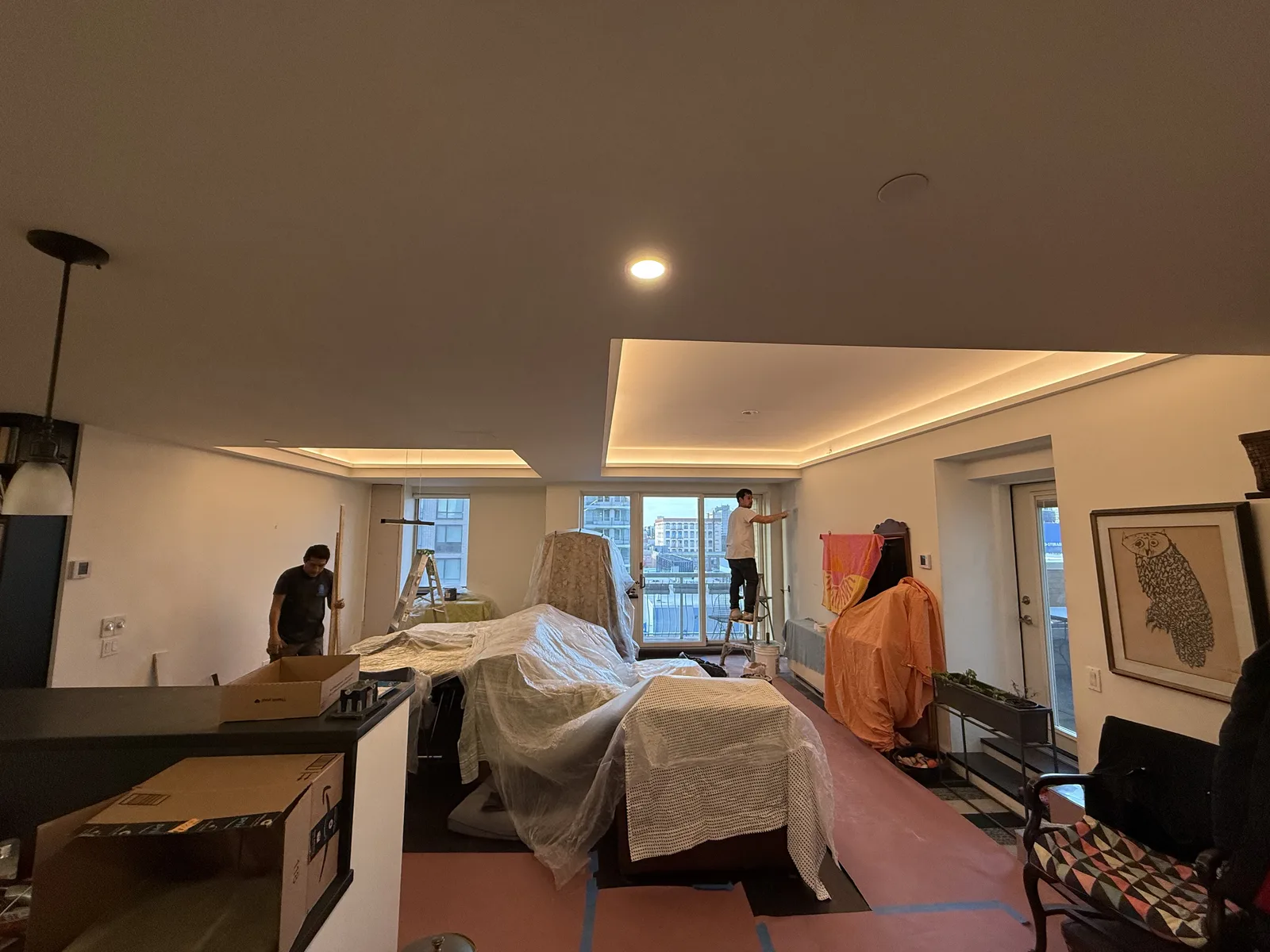 Apartment living room renovation in progress with protected furnishings in New York City