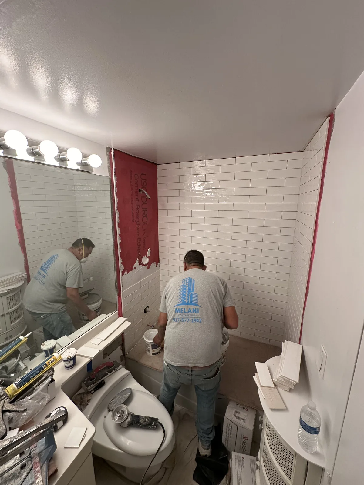 Bathroom renovation with white subway tile being installed over cement board in New York City