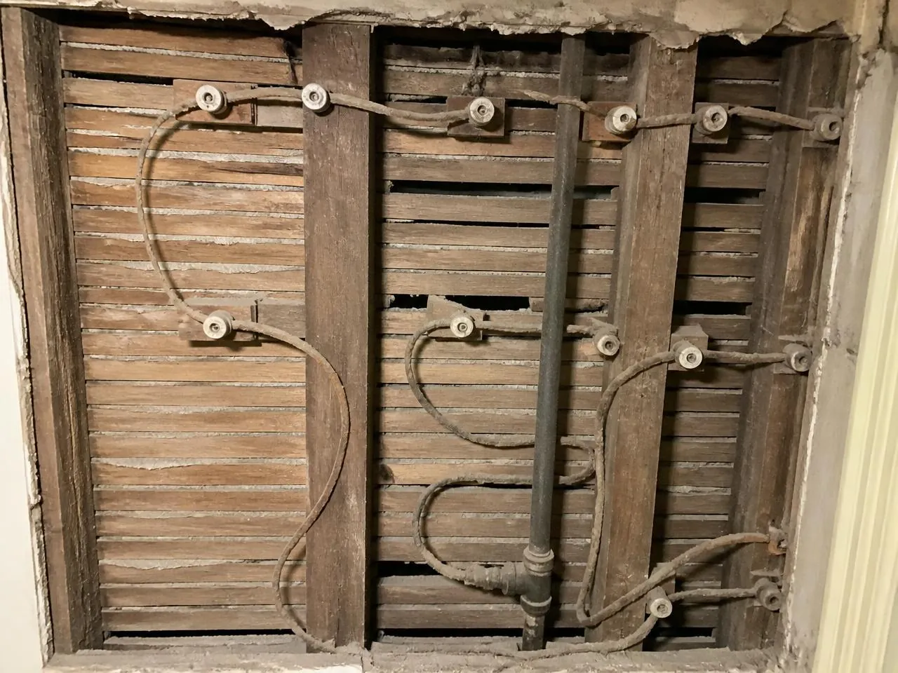 Deteriorated knob-and-tube wiring exposed in a pre-war NYC apartment wall before rewiring