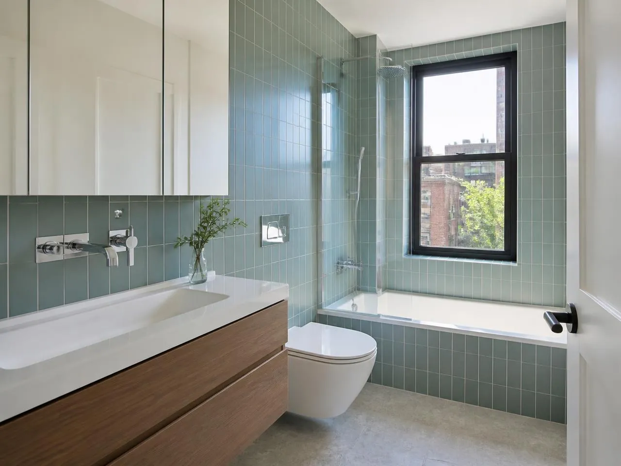 Newly installed faucet, sink, and toilet in a finished NYC bathroom — fixture installation by a licensed plumber