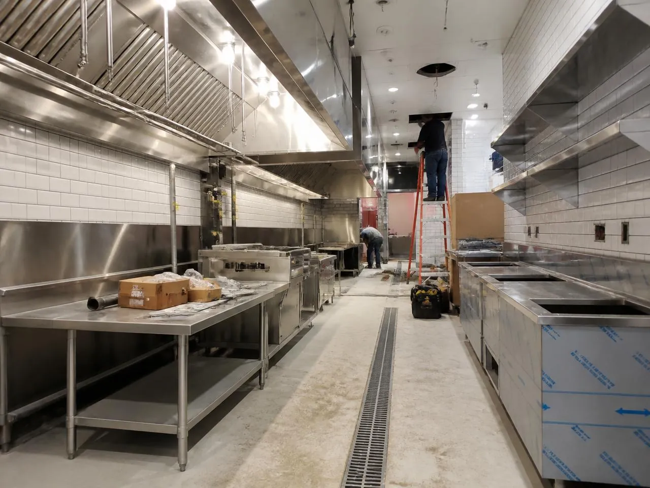 Commercial renovation NYC restaurant kitchen installation with hood ventilation and floor drains