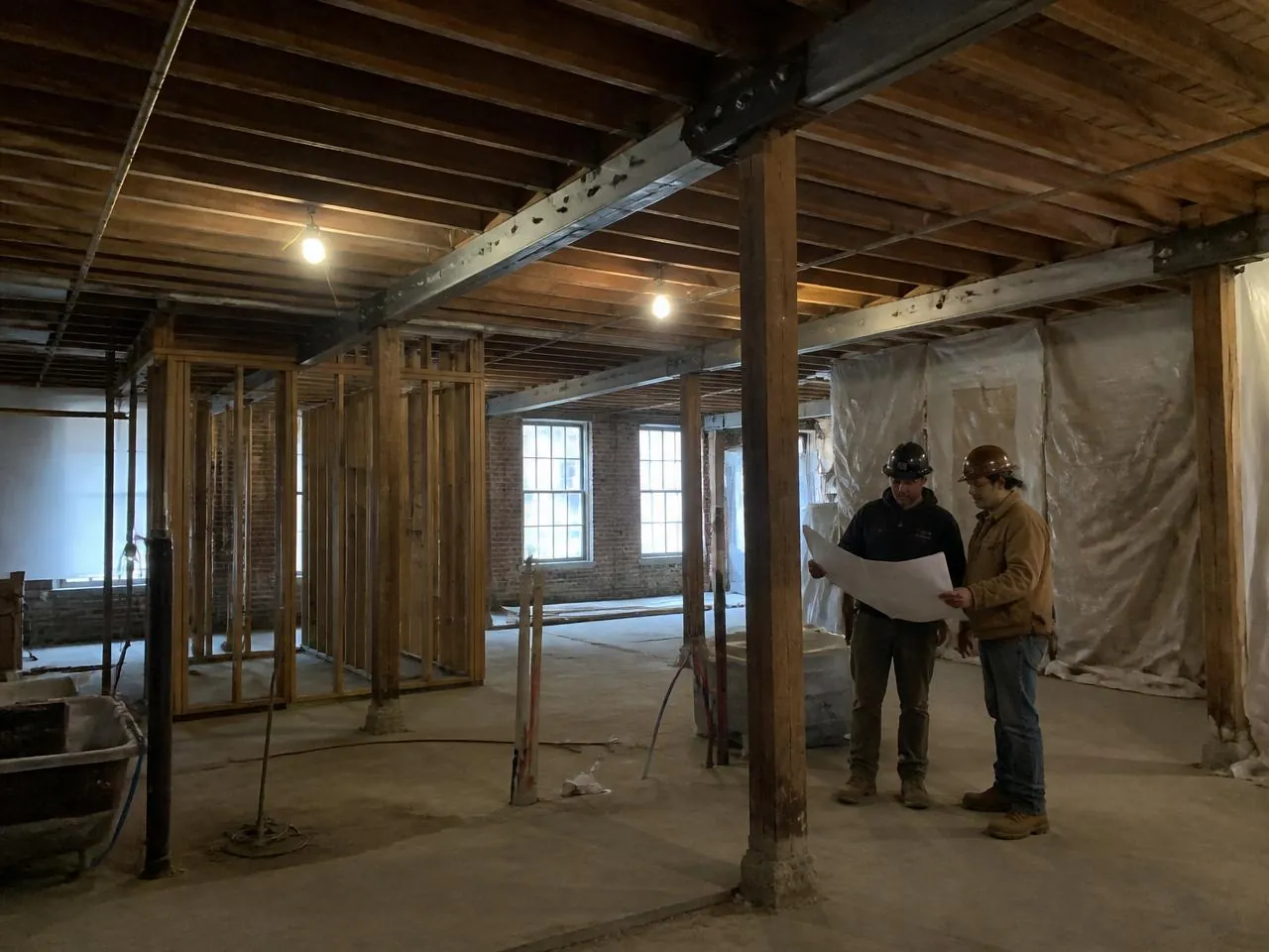 Gut renovation in progress inside a 19th-century Manhattan loft with exposed joists and steel reinforcement