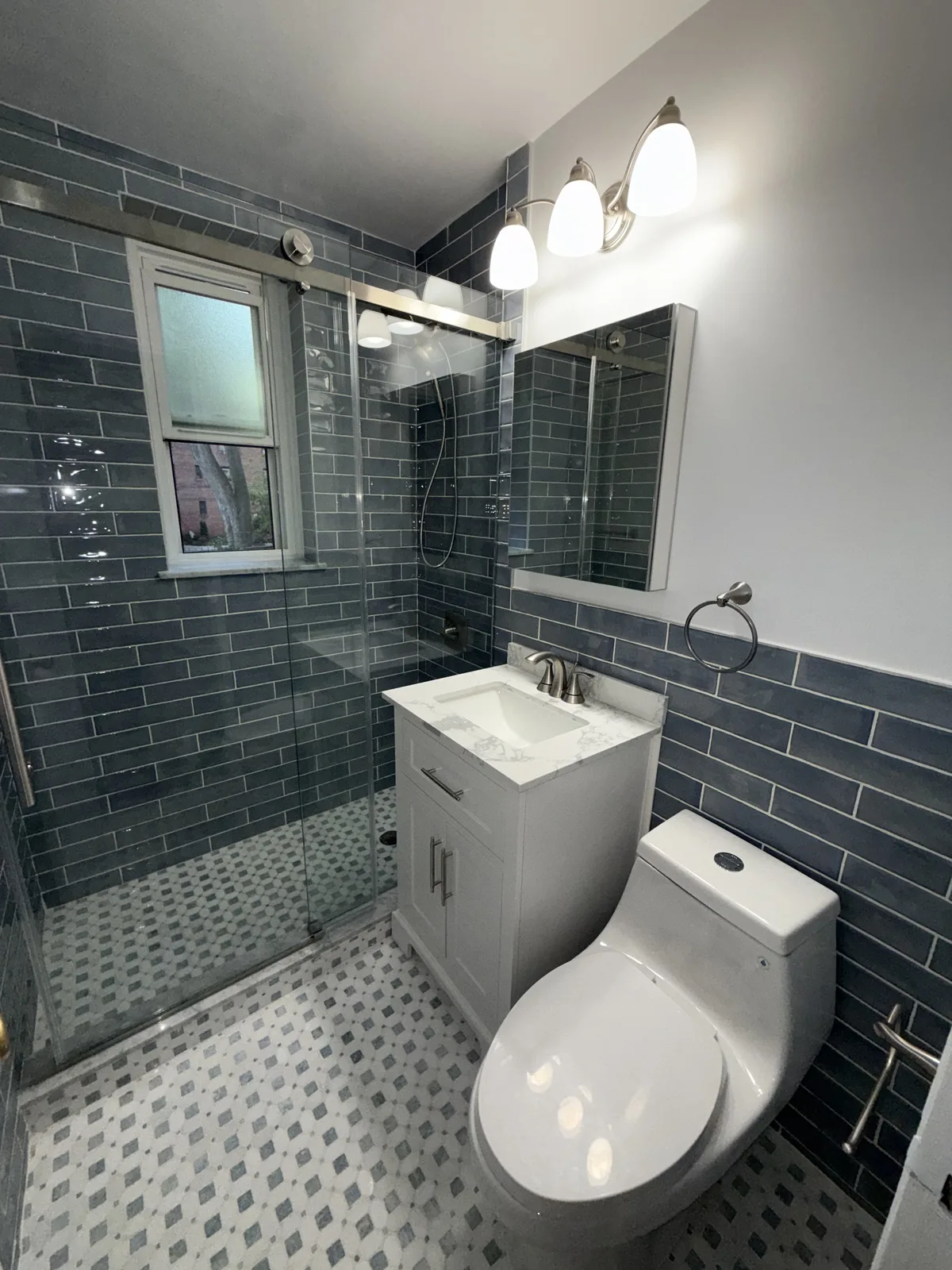Bathroom remodel with blue subway tile walk-in shower in New York City