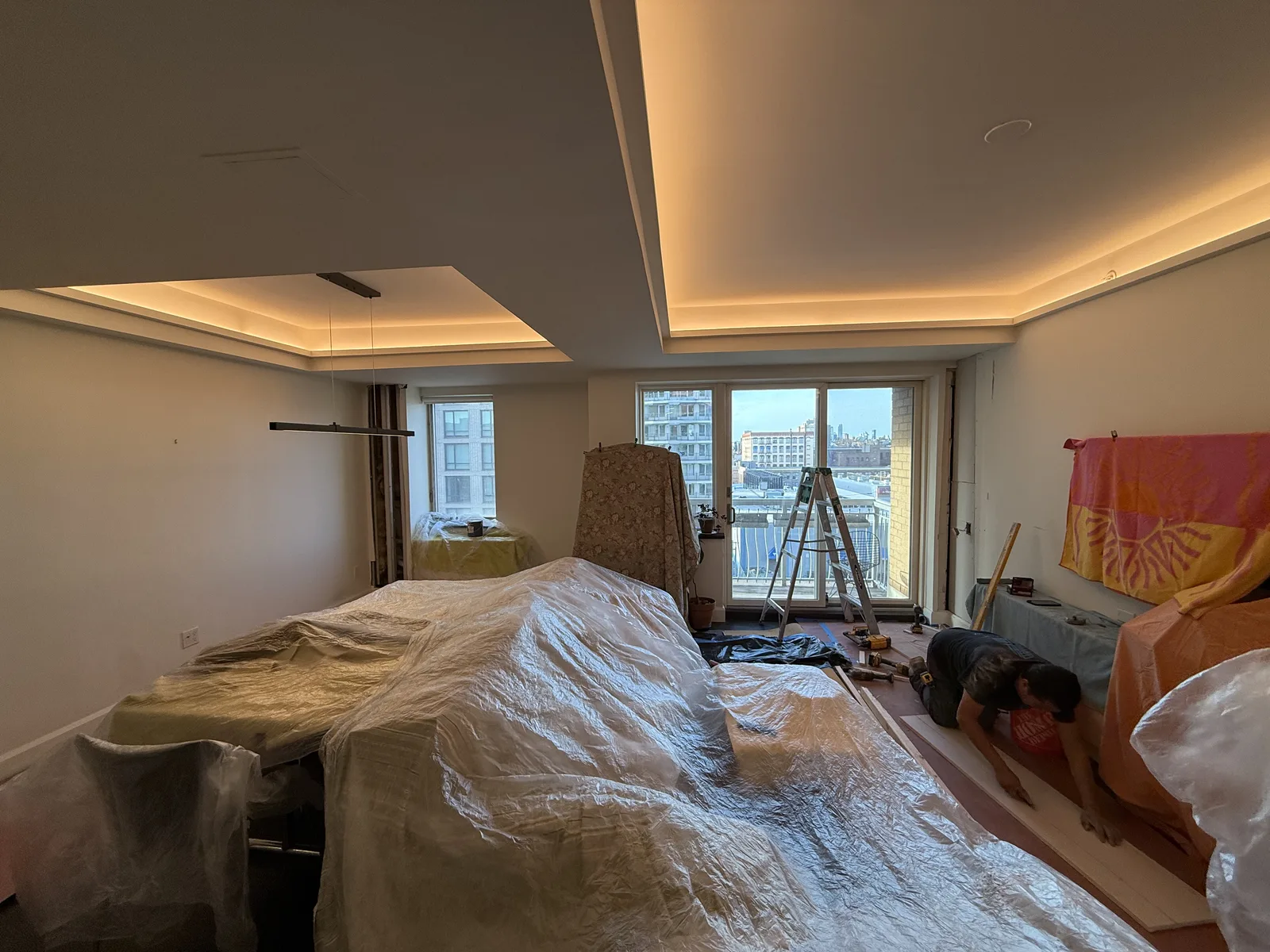 Hardwood floor installation in a living room with LED cove ceiling in New York City