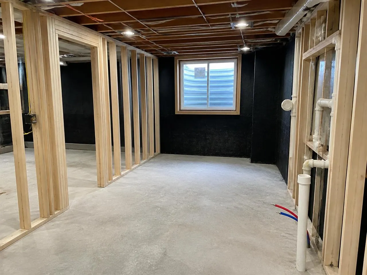 Garden level conversion of a Brooklyn brownstone with waterproofed foundation walls, egress window, and plumbing rough-in